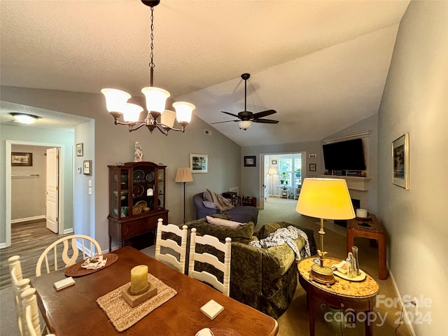 dining area featuring a textured ceiling, lofted ceiling, ceiling fan with notable chandelier, and hardwood / wood-style floors