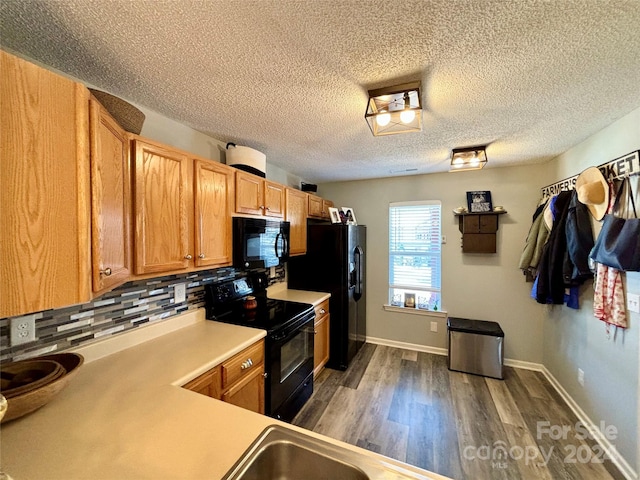 kitchen featuring black appliances, tasteful backsplash, a textured ceiling, and dark hardwood / wood-style flooring