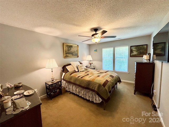 bedroom with ceiling fan, carpet, and a textured ceiling