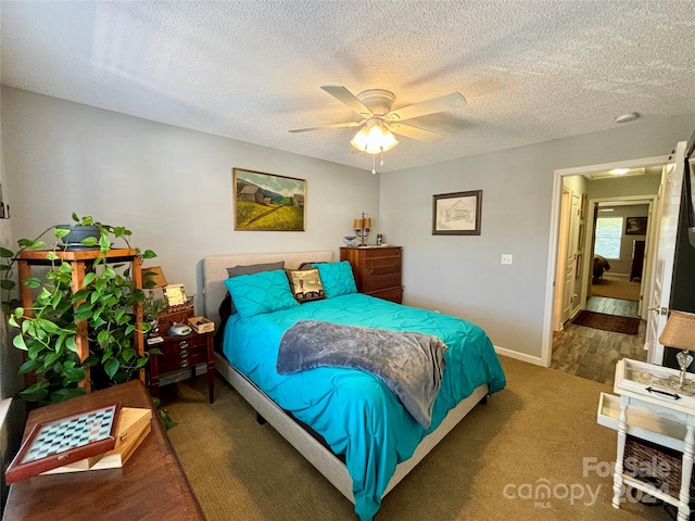 bedroom featuring hardwood / wood-style flooring, a textured ceiling, and ceiling fan