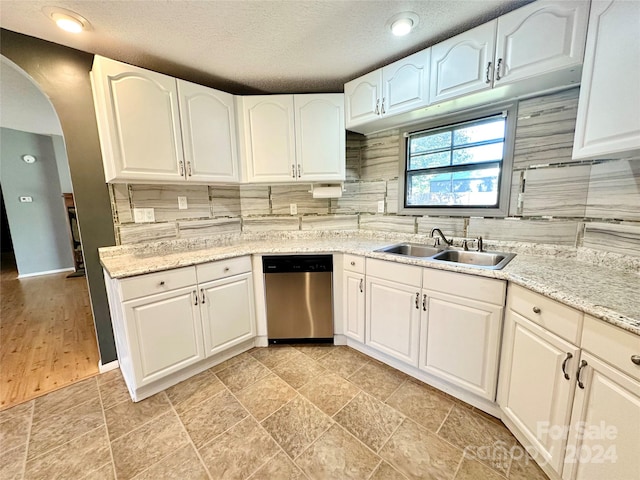 kitchen with sink, stainless steel dishwasher, and white cabinetry