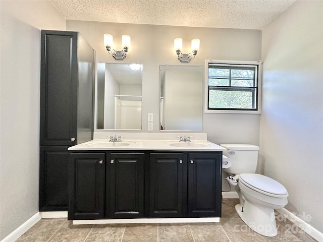 bathroom with a textured ceiling, walk in shower, vanity, and toilet