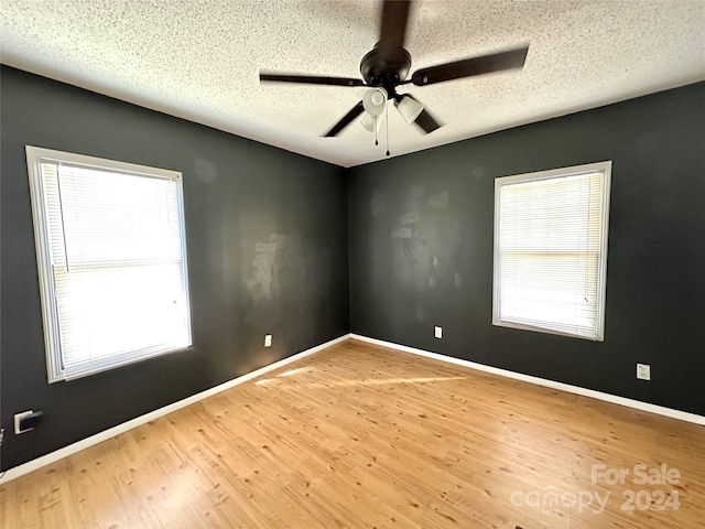 unfurnished room with wood-type flooring, a textured ceiling, and ceiling fan