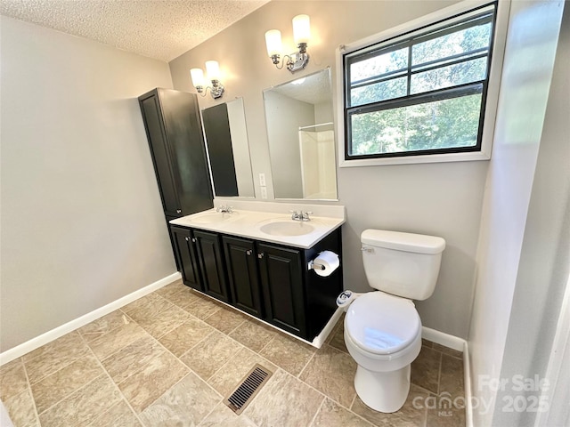 full bath with visible vents, toilet, a sink, a textured ceiling, and baseboards