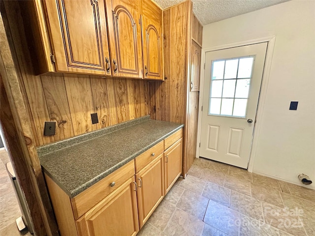 interior space with dark countertops, brown cabinets, and a textured ceiling