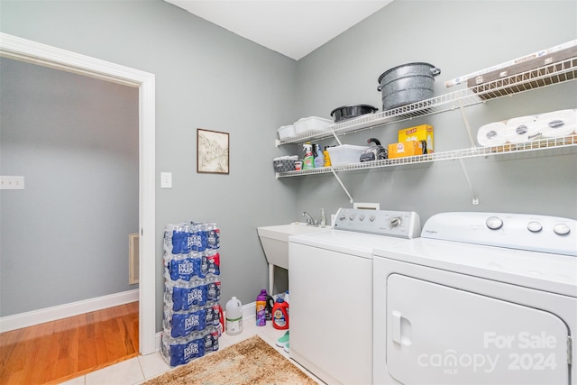 laundry area featuring washing machine and dryer and light hardwood / wood-style floors