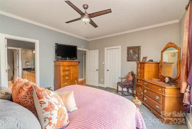 carpeted bedroom featuring crown molding, ensuite bathroom, and ceiling fan