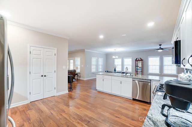 kitchen featuring appliances with stainless steel finishes, white cabinets, sink, and light wood-type flooring