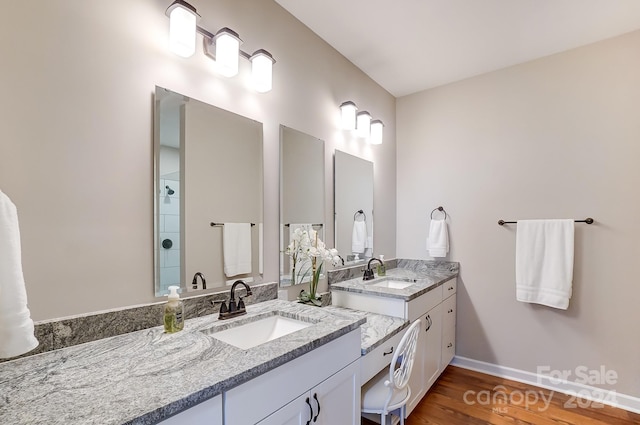 bathroom featuring vanity, wood-type flooring, and walk in shower