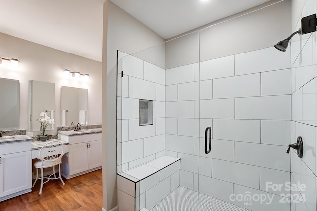 bathroom with vanity, walk in shower, and wood-type flooring