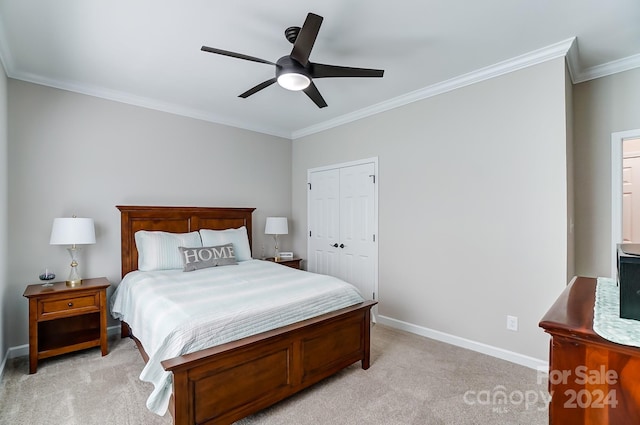 bedroom featuring a closet, ceiling fan, light carpet, and ornamental molding