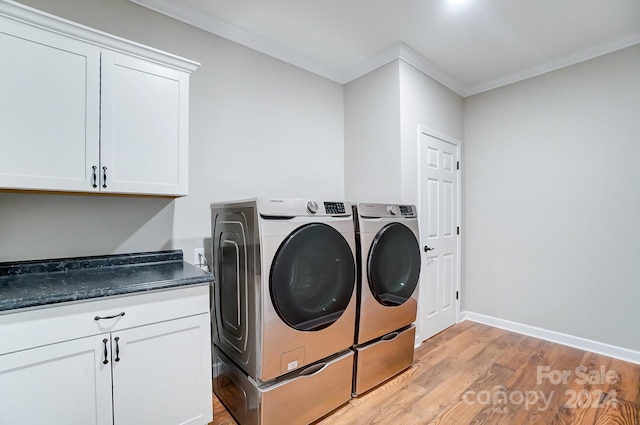 laundry area with ornamental molding, independent washer and dryer, light wood-type flooring, and cabinets