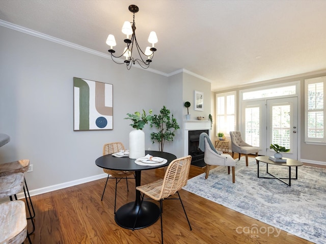 dining room with an inviting chandelier, ornamental molding, and dark wood-type flooring