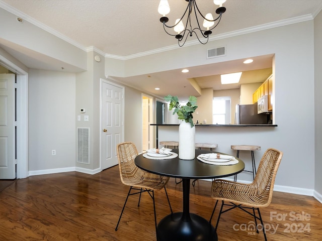 dining room with crown molding, a textured ceiling, dark hardwood / wood-style floors, and a chandelier