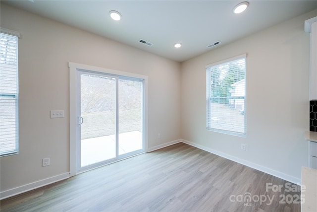 empty room with light hardwood / wood-style flooring