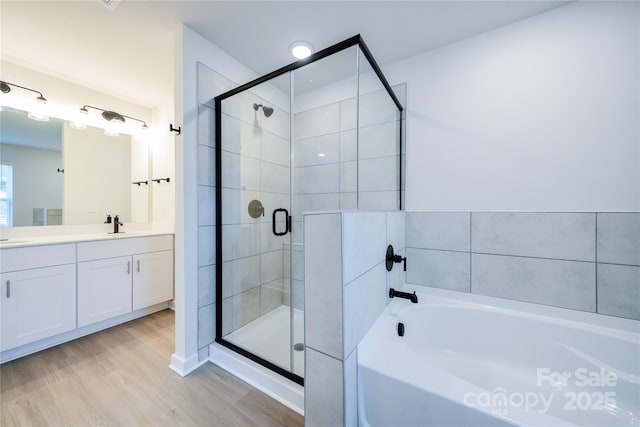 bathroom with vanity, hardwood / wood-style floors, and separate shower and tub