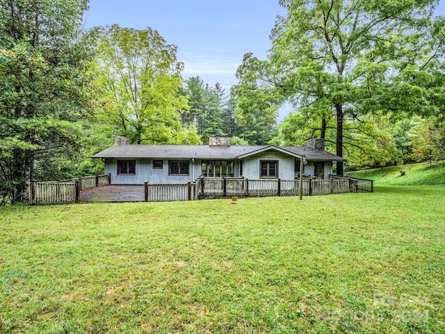 back of house with a wooden deck and a lawn