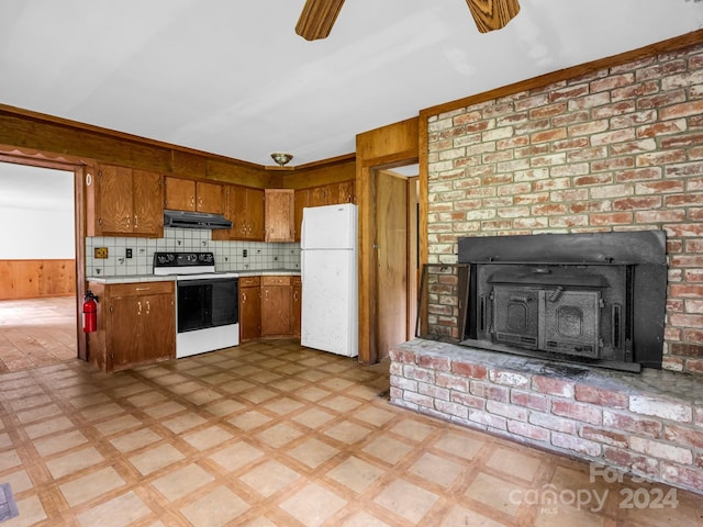 kitchen with ceiling fan, decorative backsplash, white appliances, and wood walls