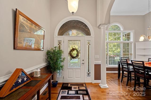 entryway with decorative columns and wood-type flooring