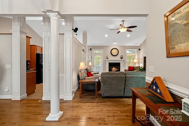 living room with ceiling fan, lofted ceiling, and light hardwood / wood-style flooring