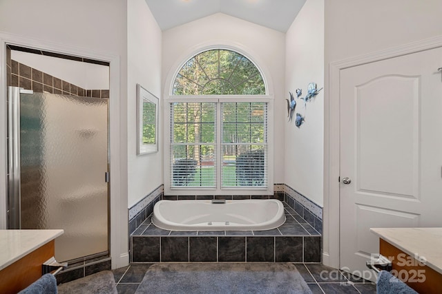 bathroom with tile patterned flooring, vanity, vaulted ceiling, and shower with separate bathtub