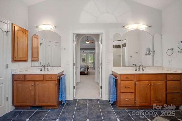 bathroom with ceiling fan, walk in shower, tile patterned flooring, lofted ceiling, and vanity