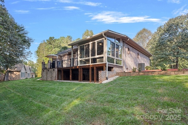 rear view of property with a sunroom and a yard