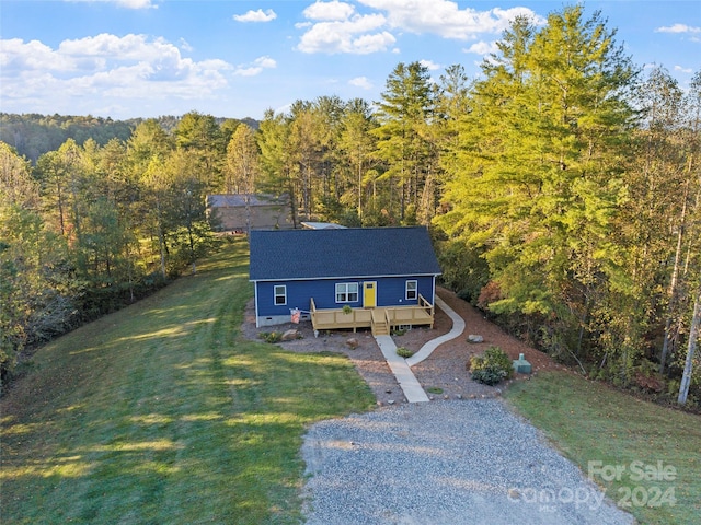 view of front of property featuring a front lawn and a wooden deck