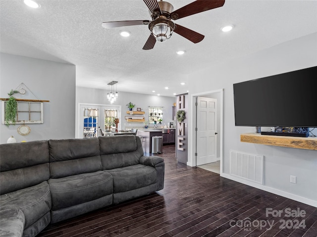 living room featuring dark wood-type flooring, french doors, a textured ceiling, and ceiling fan