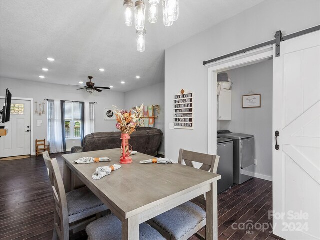 dining room featuring a barn door, ceiling fan, dark hardwood / wood-style flooring, and washer and clothes dryer