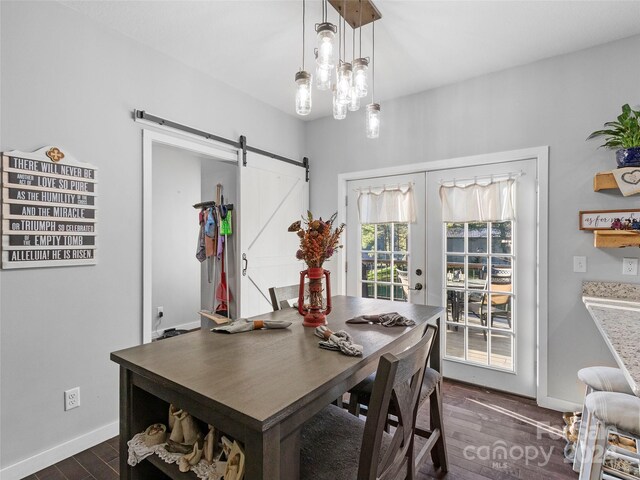 dining area featuring a barn door, french doors, and dark hardwood / wood-style flooring