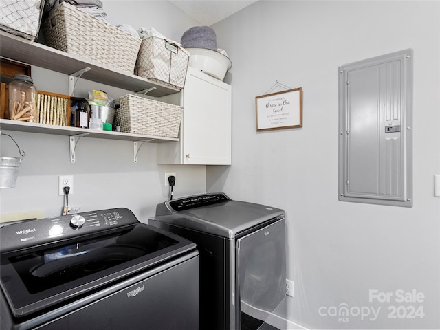 washroom featuring independent washer and dryer, electric panel, and cabinets