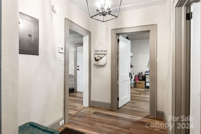 515 Suttle St, Shelby, NC 28150 - corridor featuring baseboards, an inviting chandelier, electric panel, and wood finished floors