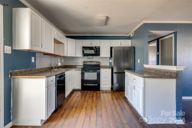 kitchen featuring sink, dark wood-type flooring, tasteful backsplash, white cabinets, and black appliances