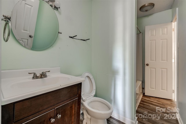 bathroom with hardwood / wood-style flooring, vanity, and toilet