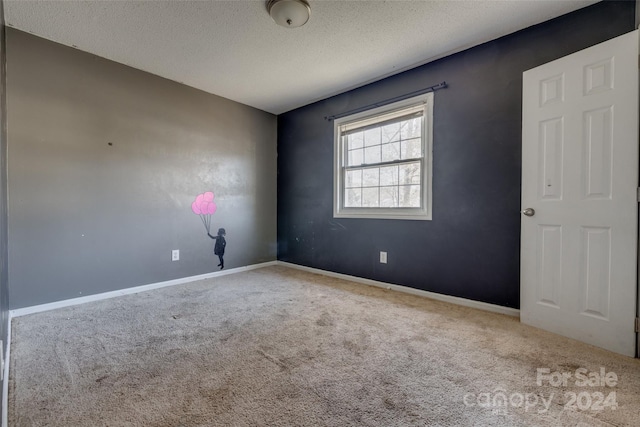 carpeted empty room with a textured ceiling