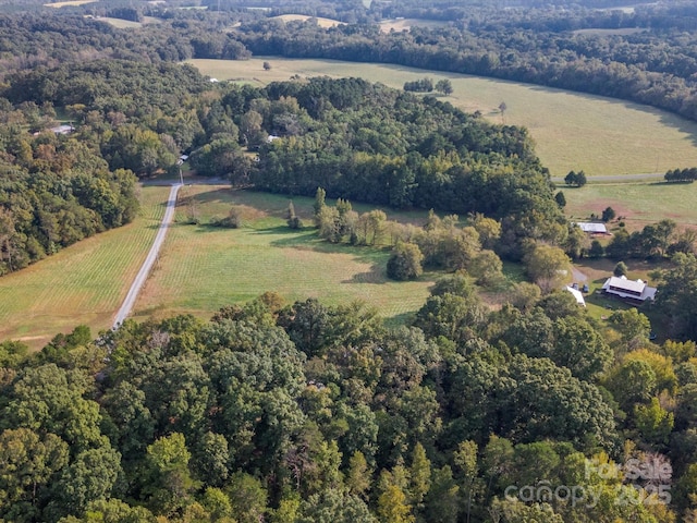 birds eye view of property with a rural view and a wooded view