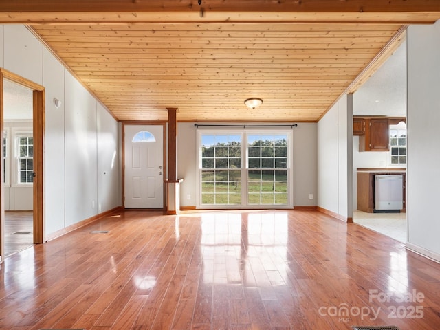 interior space with light wood finished floors, crown molding, baseboards, lofted ceiling, and wooden ceiling