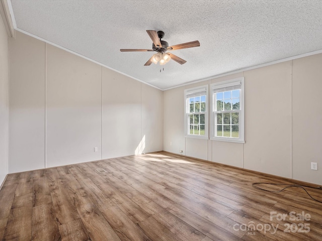 unfurnished room featuring ceiling fan, wood finished floors, a textured ceiling, and ornamental molding