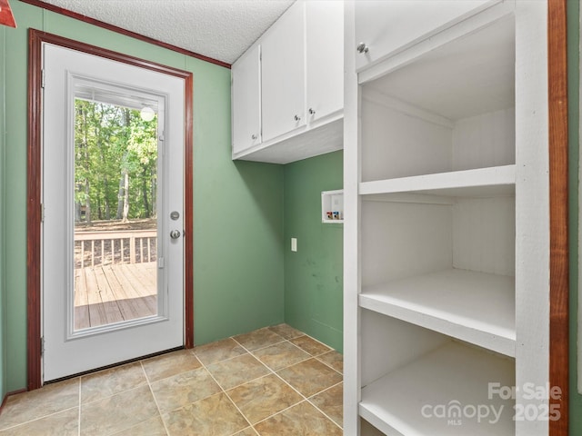 clothes washing area with a textured ceiling