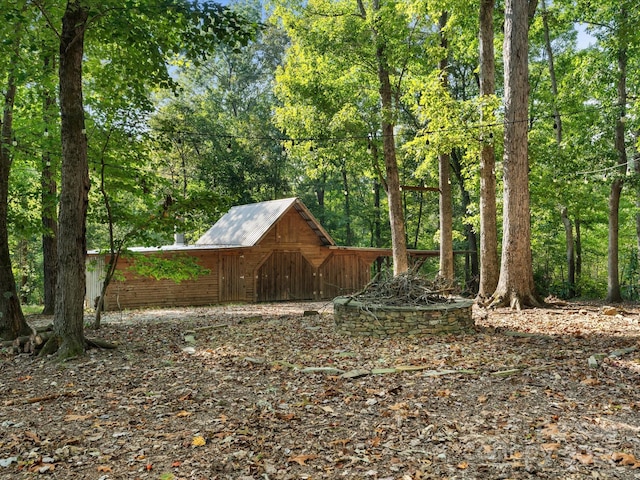 view of yard featuring an outdoor structure and a forest view