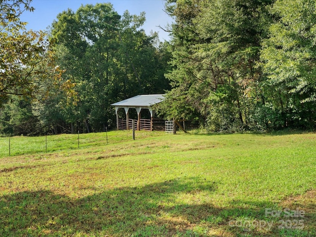 view of yard featuring an outdoor structure and a forest view