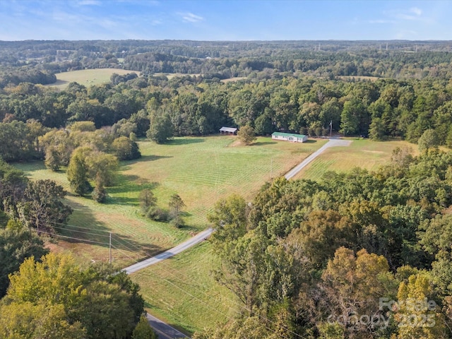 birds eye view of property featuring a rural view and a wooded view