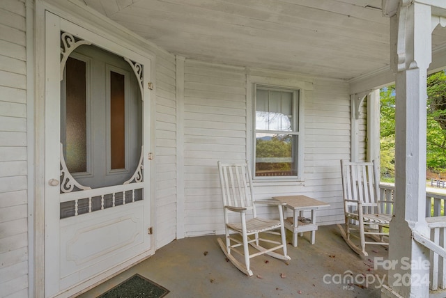 view of exterior entry featuring covered porch