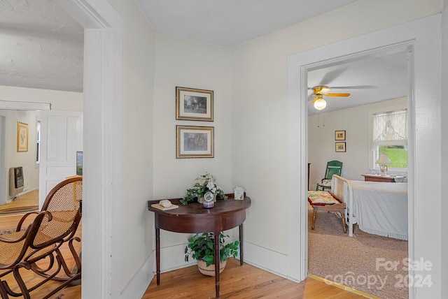 hallway with hardwood / wood-style flooring and heating unit