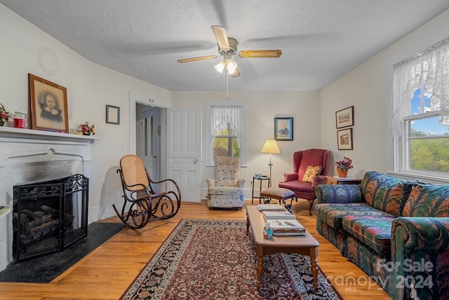 living room featuring a wealth of natural light, a textured ceiling, hardwood / wood-style flooring, and ceiling fan