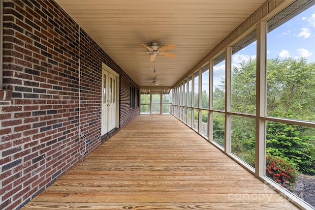 unfurnished sunroom featuring ceiling fan