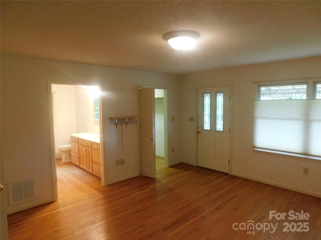 2066 Waterford Way, Morganton, NC 28655 - entrance foyer featuring light wood-type flooring, baseboards, visible vents, and a textured ceiling