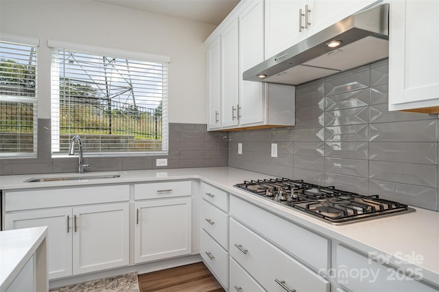 kitchen featuring sink, white cabinetry, stainless steel gas stovetop, and backsplash