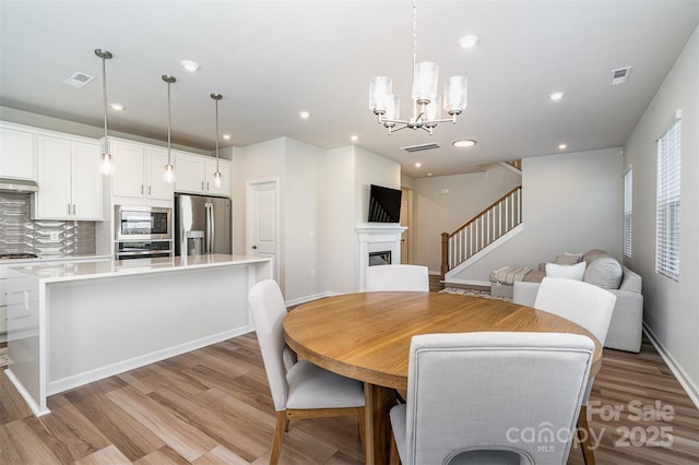 dining area with a chandelier and light wood-type flooring